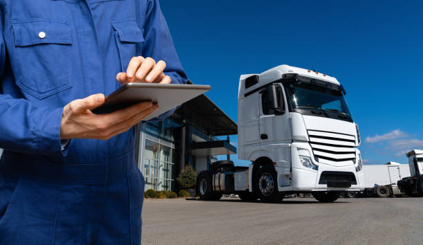 istock Manager with a digital tablet next to trucks. 1729230425