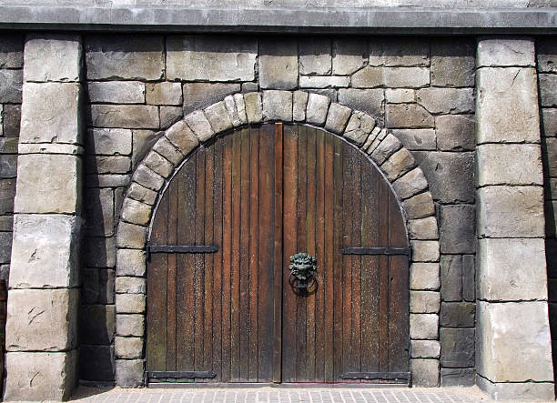 Wooden arched doors surrounded by stones in medieval design stock photo