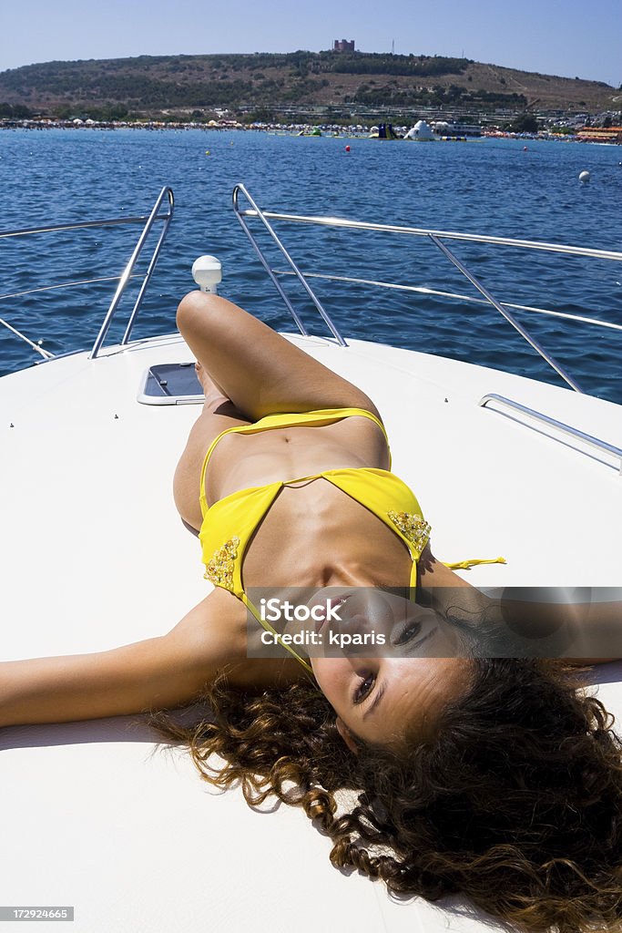 Beauty relaxing on boat ... in a bright yellow bikini 18-19 Years Stock Photo