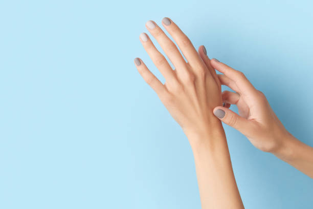 istock Womans hands with gray nail design on blue background 1729253579