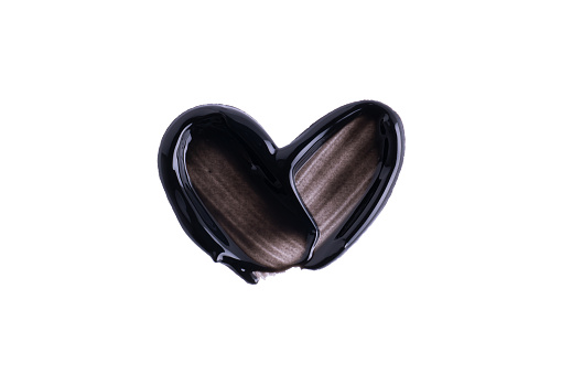 Smear of a black magnetic, jelly or charcoal mask in a heart shape  isolated on white background. Beauty makeup product swatch. A smear of black cream or paint texture. Smudge texture brush stroke