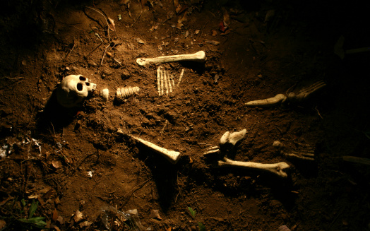 Shallow grave of a skeleton.  Skeleton is faux.