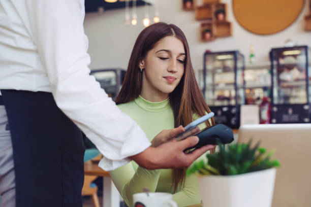 istock Young woman making card payment in cafeteria, summer bar. 1729262361
