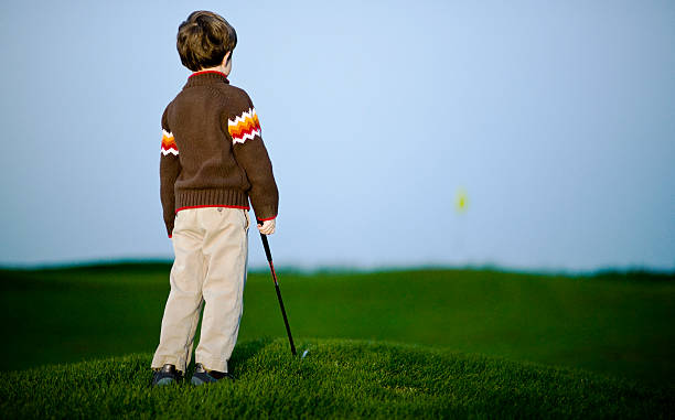 young boy 探して、ゴルフコースのグリーン - putting green practicing putting flag ストックフォトと画像