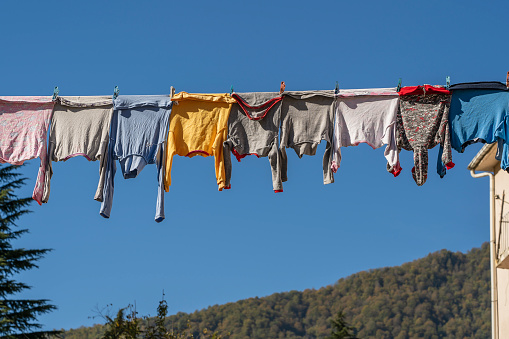 Clothes hand on drying rack on balcony above forest and hills in autumn