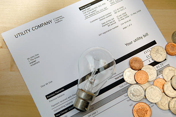Electric Bill with lightbulb and coins. utility bill with lightbulb and coins tungsten image stock pictures, royalty-free photos & images