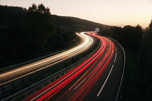 Traffic light trails on a two lane highway at dusk