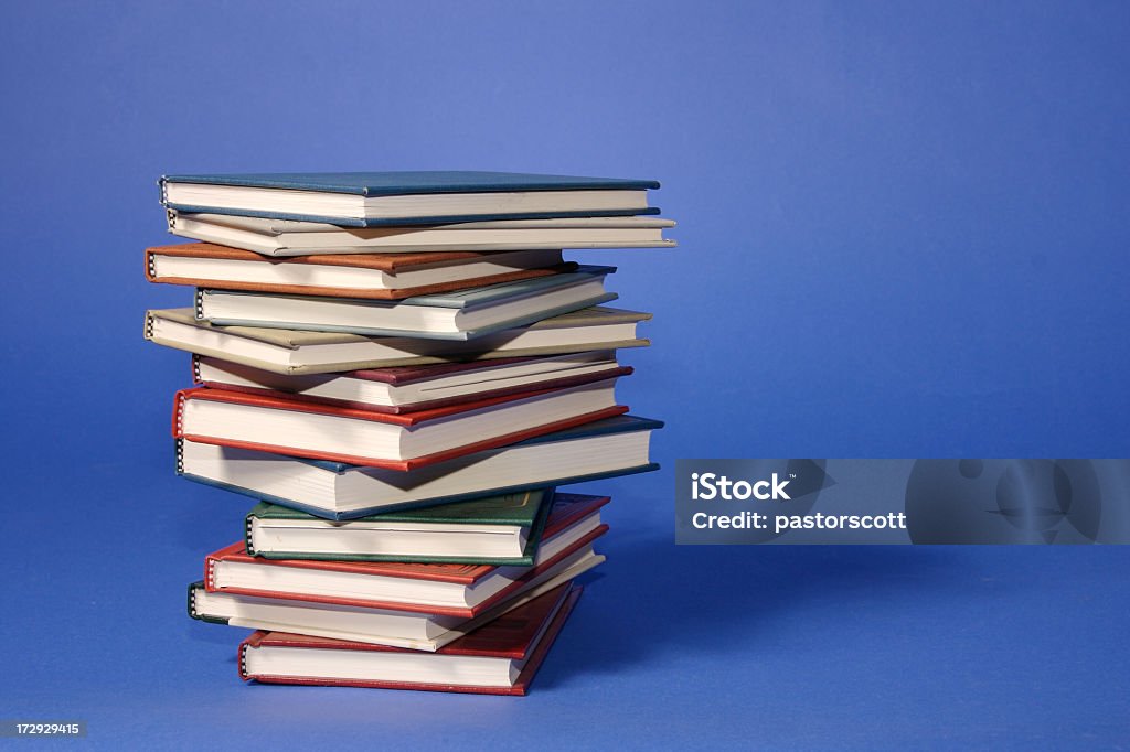 Stack of Books Side view of stack of books on blue background Book Binding Stock Photo