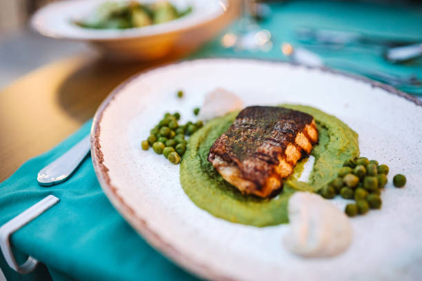 Grilled salmon steak served on peas puree. Fine dining