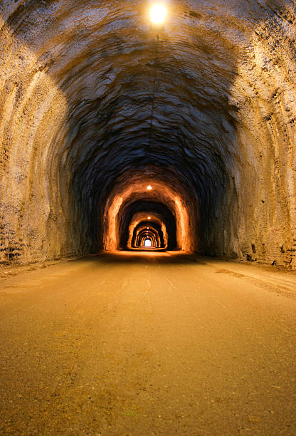 istock Long, dusty tunnel lit with overhead bulbs 172930911