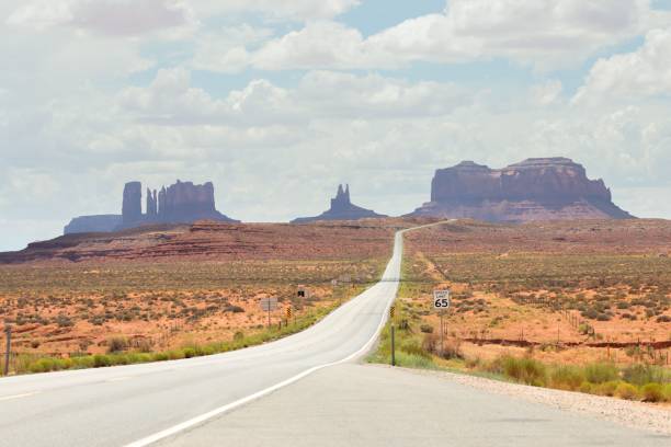 istock the long road is in between some tall, red rock formations 1729312831