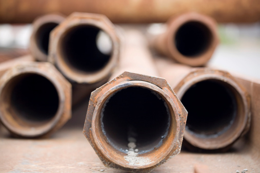 Rusty metal pipes at a recycling or construction yard.
