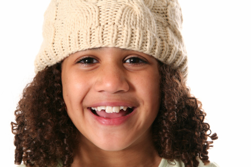 Little girl wearing a warm knitted hat on a white background