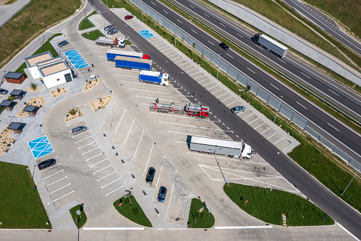 Truck stop parking with rest area on a rural highway in summer viewed from above.