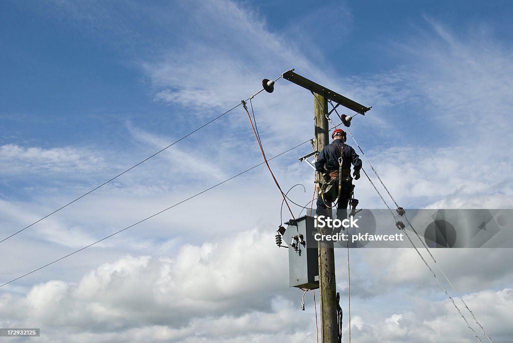 Man at Work An unrecognisable utility workman carries out repairs on a transformer connected to an 11000 volt power line. Power Line Stock Photo