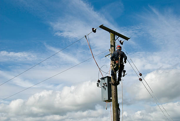 Man at Work An unrecognisable utility workman carries out repairs on a transformer connected to an 11000 volt power line. telephone line stock pictures, royalty-free photos & images