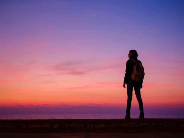 istock Woman tourist against sunset sky 1729323619