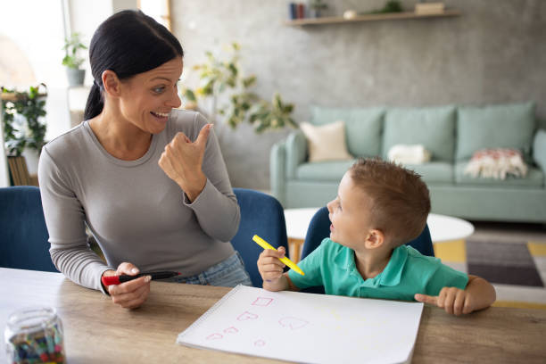 istock Babysitter drawing with a boy that she's taking care of 1729327645