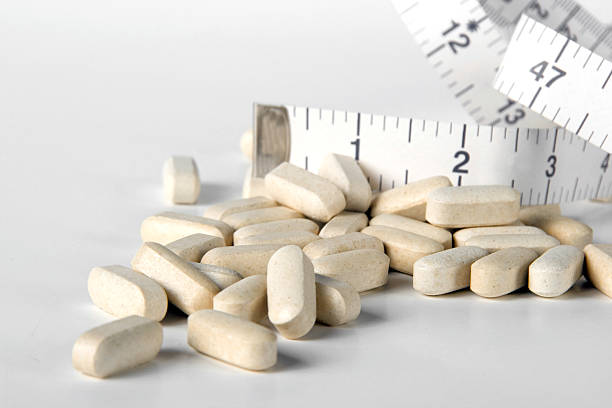 istock Diet pills and tape measure 172933204