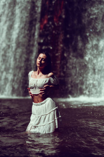 istock Female Washing Her Whole Body In Cold Waterfall 1729334424