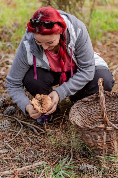 istock Red-haired woman smiling for having found a mushroom 1729337149