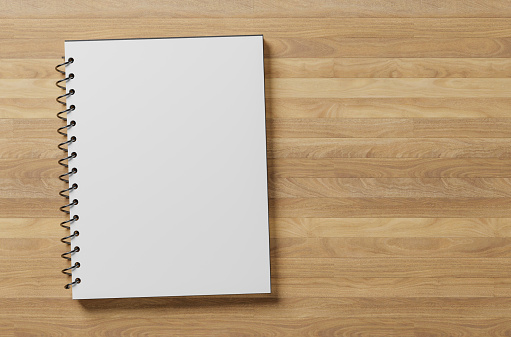 white blank notepad sheet mockup. spiral notepad on wooden table. top view. copy space