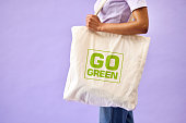 Sustainable, shopping and eco friendly bag by person or recycling customer isolated in a studio purple background. Environment, retail and woman with carbon footprint, zero waste and grocery