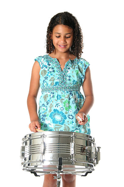 Playing a Drum Little girl playing a snare drum on a white background snare drum stock pictures, royalty-free photos & images