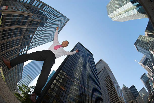 istock Businessman Jumps in Skyscraper Canyon 172935639