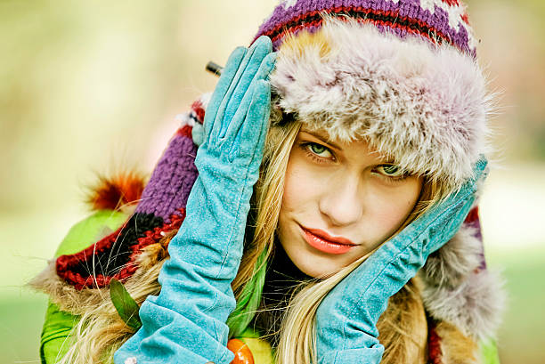 Latin girl with a black jacket, scarf and red woolen hat enjoying in an autumn park, portrait smiling looking at camera