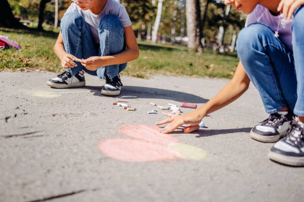 istock Girls having fun in public park drawing with chalk 1729364641