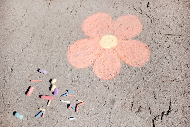 Girls enjoying on sunny day in the public park and drawing with chalks