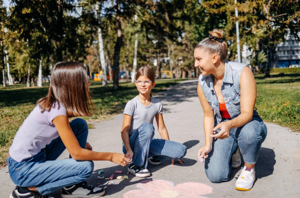 istock Girls having fun in public park drawing with chalk 1729367344