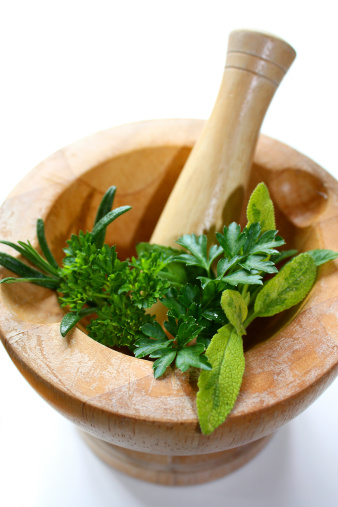 Pestle and Mortar with herbs on a white background.