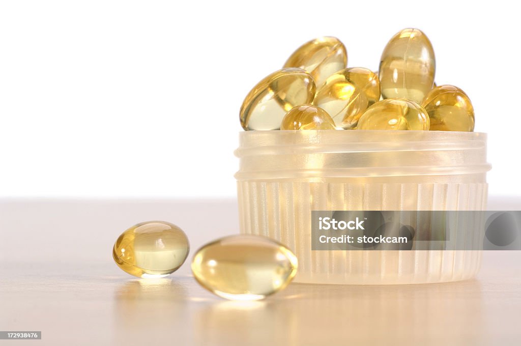 Cod liver oil supplement pills Cod liver oil capsules on a wooden table. Addiction Stock Photo