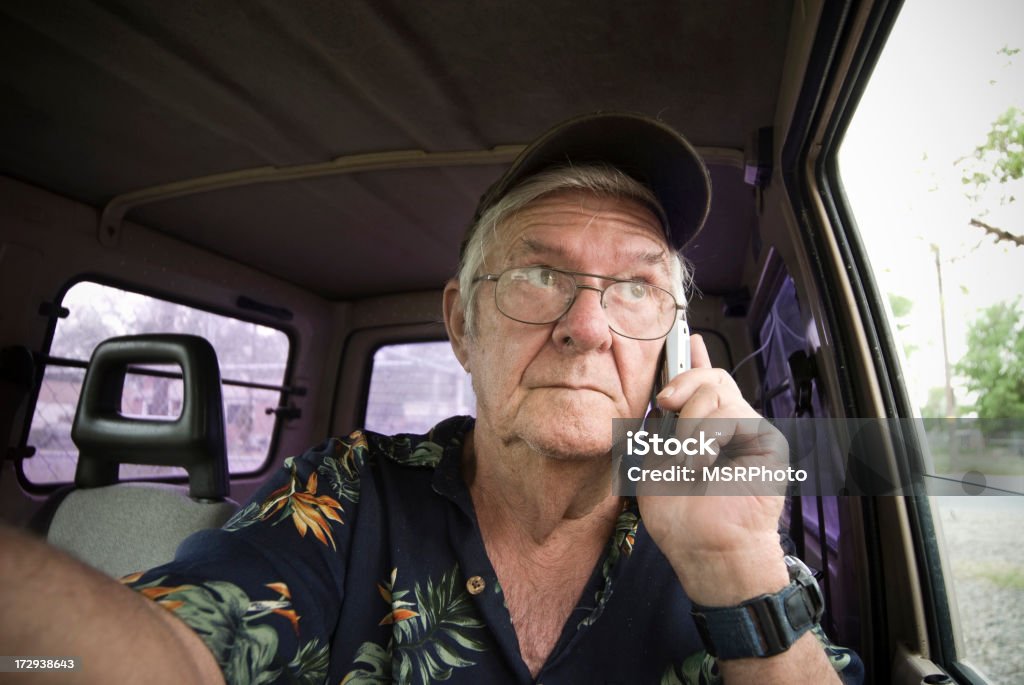 Cell Phone and Driving A senior citizen uses a cell phone while driving. Car Stock Photo