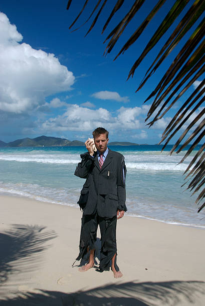 uomo d'affari sta parlando su shellphone spiaggia tropicale - stranded beached beach businessman foto e immagini stock