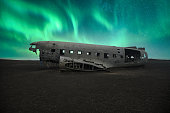 dc 3 plane wreckage under a northern lights