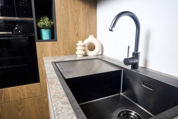 istock Urban rustic loft style kitchen interior in wooden facade and stoneware countertop tabletop with built-in appliances as black faucet with stainless steel square sink microwave oven and oven. 1729399295