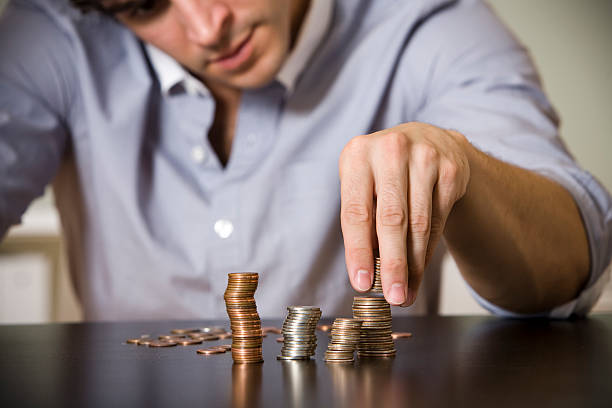 istock Man counting stacks of coins on table 172939978