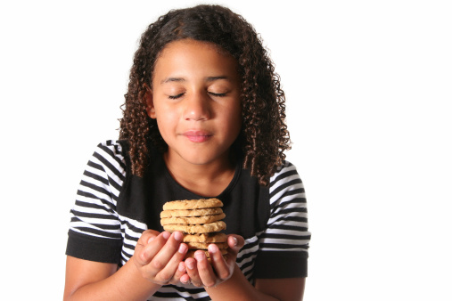 Little girl savors the scent of homemade peanut butter cookies