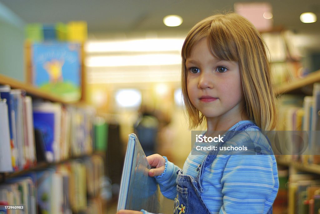 Niña la búsqueda en la biblioteca - Foto de stock de Biblioteca libre de derechos