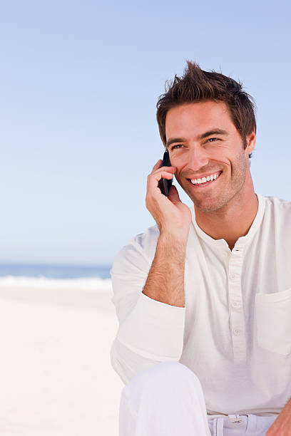istock Happy young man using cell phone against blue sky 172941686