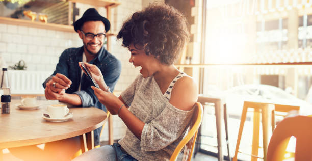 istock Happy woman using a tablet while hanging out with a friend at a cafe 1729421478