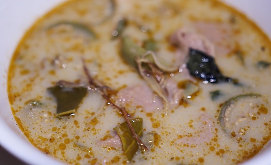 a bowl of soup with a leaf in it.