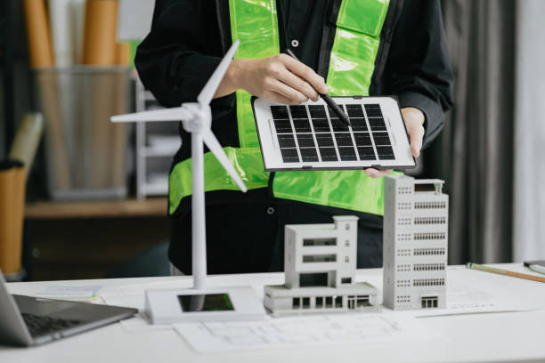 istock Architect  working with blueprints for sketching a construction project, green energy and solar panel concept. 1729424789
