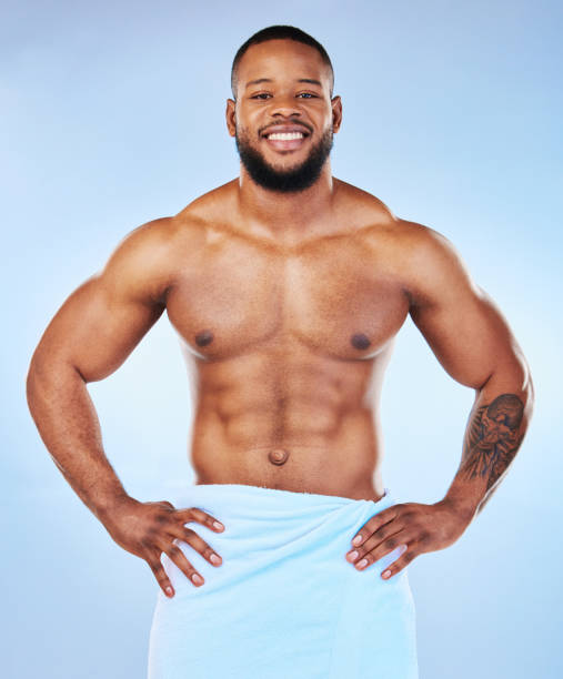 mann körpermuskel, handtuch und porträt eines männlichen lächelns mit glück von bodybuilder-übung. reinigung, hautpflege und wellness nach dem training und fitness mit isoliertem, studio- und blauem hintergrund - shower portrait male beauty chest stock-fotos und bilder