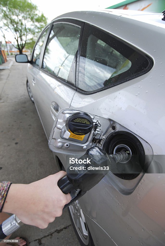 Filling up a Hybrid Young woman filling the tank of a hybrid vehicle. Adult Stock Photo