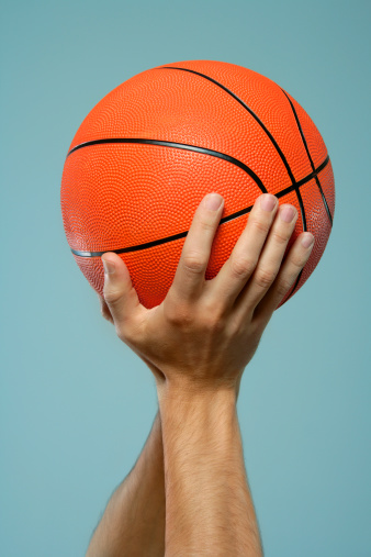 Male hands holding basketball.