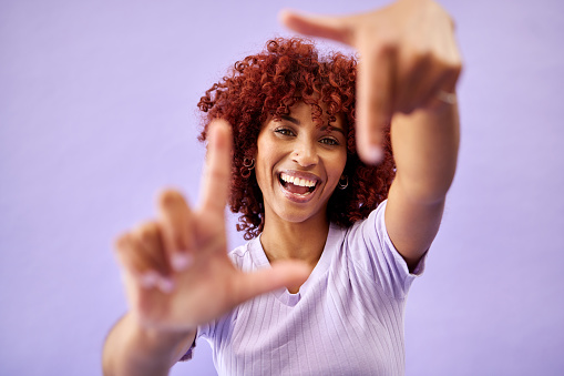 Portrait, hands frame and happy woman in studio isolated on a purple background mockup space. Face, finger border and person excited for photographer selfie, profile picture and creative perspective
